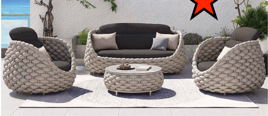A contemporary circular or oval-shaped outdoor daybed featuring a thick, tightly woven light-colored synthetic rope exterior, forming a deep, cocoon-like seating area. It is furnished with dark grey seat and back cushions, complemented by lighter accent pillows for comfort. — 3D model