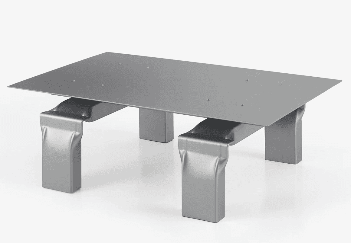 A modern coffee table with a rectangular, flat, metallic surface. The tabletop is supported by four… — 3D model