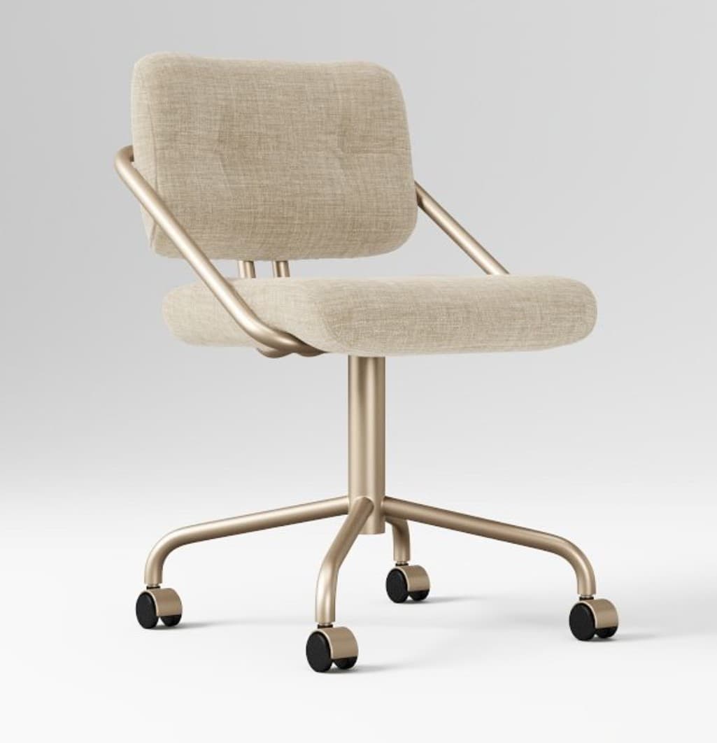 A desk chair with a fabric-upholstered seat and backrest, supported by a brushed metal frame and a five-star base with casters. The frame has a modern, minimalist design with curved armrests that extend from the backrest. The seat and back are padded and appear to have a textured linen-like fabric. The base and frame are a uniform metallic gold color. — 3D model
