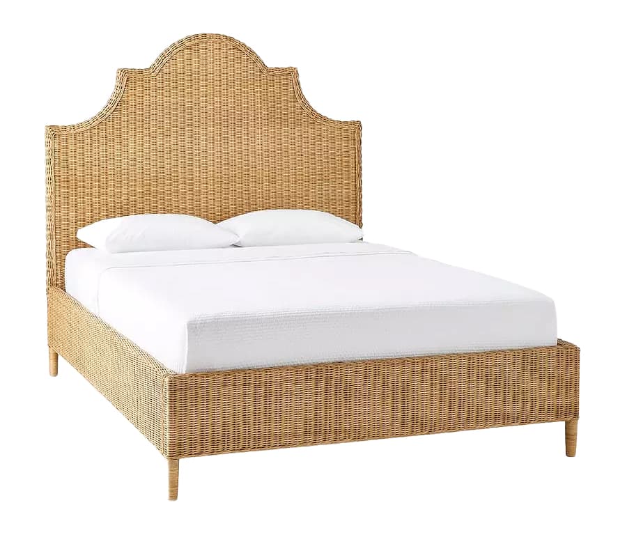 A woven rattan bed frame with a curved, scalloped headboard. The frame features a densely woven texture throughout the headboard, side rails, and footboard. The bed is shown with white bedding and two pillows. The frame is supported by four slender, tapered legs. — 3D model