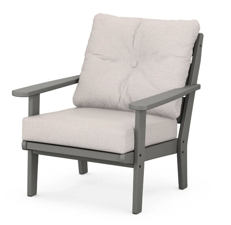 A modern armchair with a sturdy frame and comfortable cushions. The frame features clean lines and a matte finish, while the seat and back cushions are upholstered in a textured fabric. A single button is centered on the back cushion. — 3D model
