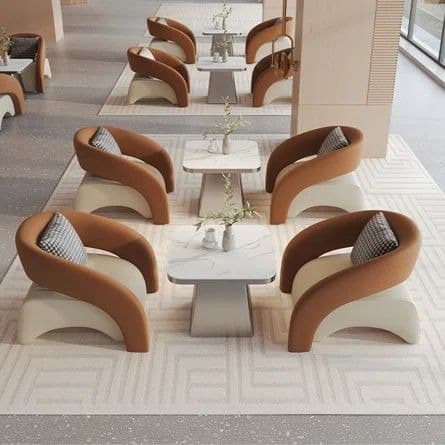 A modern armchair featuring a curved, U-shaped backrest and armrests upholstered in a textured brown fabric, resting on a sculptural, light cream base that forms the seat. A small checkered cushion is placed on the seat. — 3D model