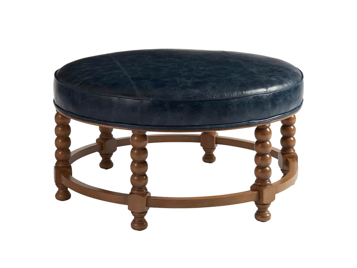 A round, upholstered ottoman featuring a dark blue leather top and a turned wooden base with distinc… — 3D model