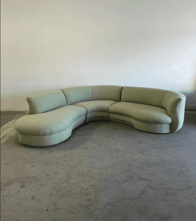 A large, curved sectional sofa with a light green upholstered finish. The sofa features a rounded ch… — free GLTF 3D model