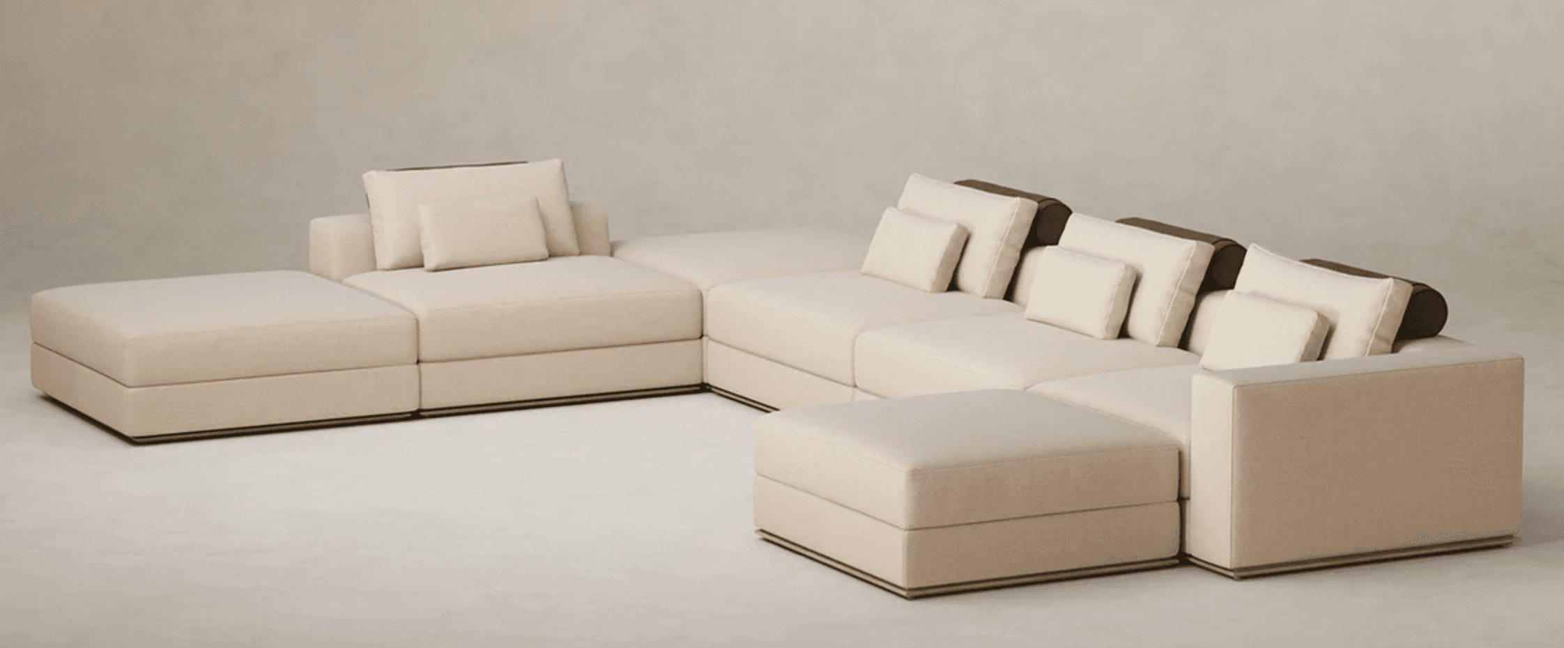 A modular sectional sofa, configured in an L-shape. It features multiple seating modules including a chaise lounge on the left, several linear sofa segments, and an ottoman or corner piece on the right. The sofa is upholstered in a textured fabric and includes several loose back cushions and two accent pillows. — 3D model