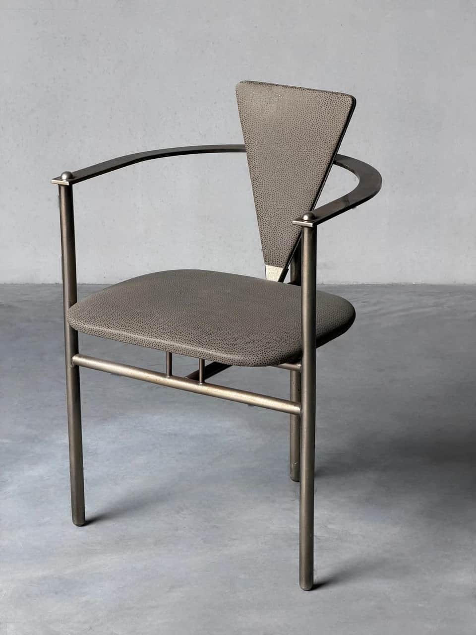 A contemporary armchair with a dark gray tubular metal frame, featuring a padded seat and a distinct… — 3D model