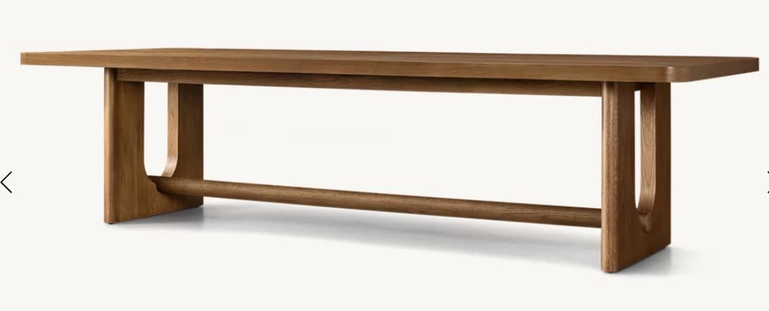 A wooden dining table with a rectangular tabletop and unique U-shaped legs connected by a horizontal stretcher bar. The wood has a visible grain and a warm, natural finish. The edges of the tabletop are rounded. — 3D model