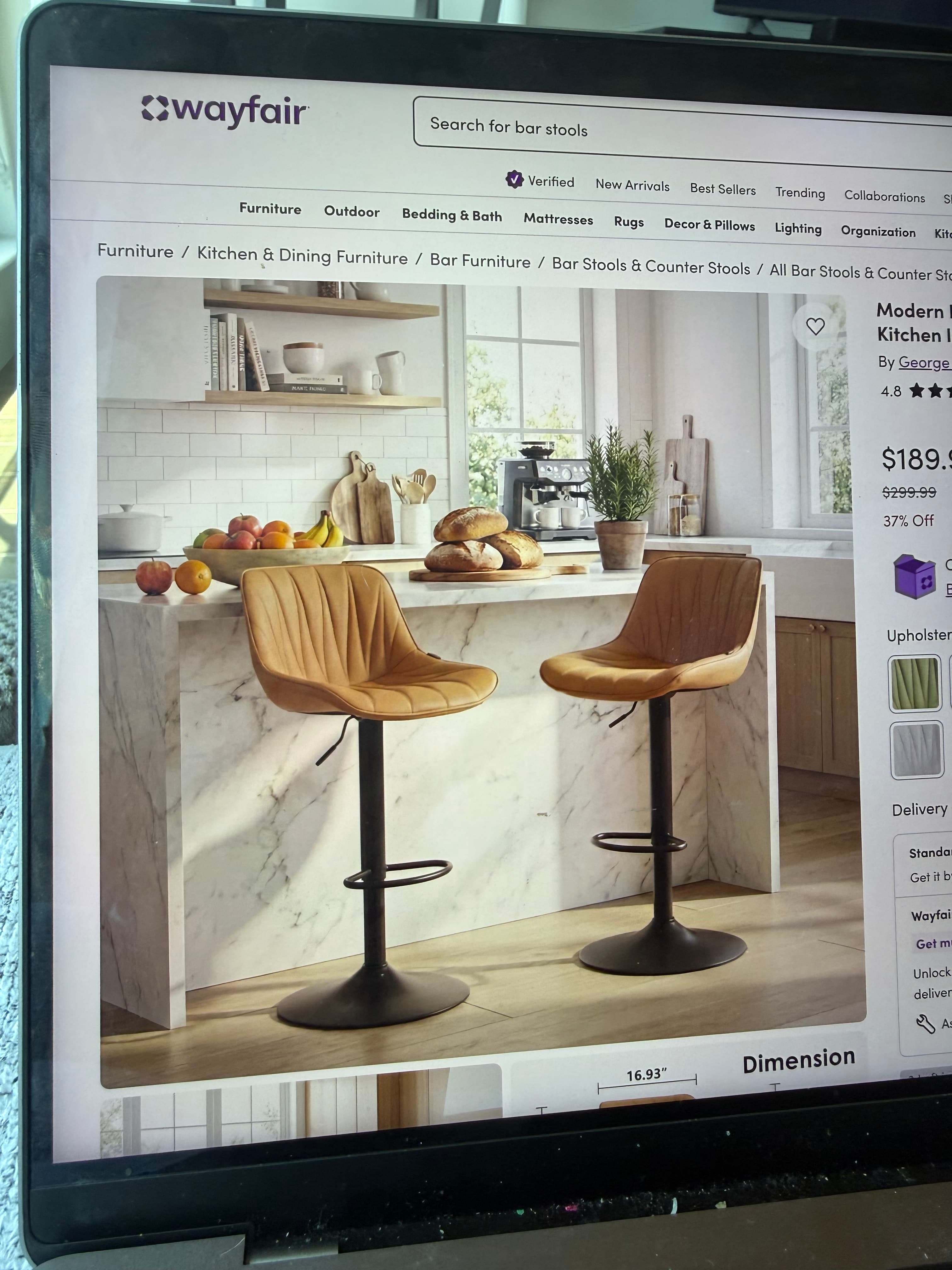 A contemporary bar stool featuring a curved, upholstered seat with distinctive pleated detailing in a light tan color. It stands on a matte black metal pedestal base with a circular footplate and includes a built-in circular footrest, indicative of a height-adjustable and swiveling mechanism. — 3D model