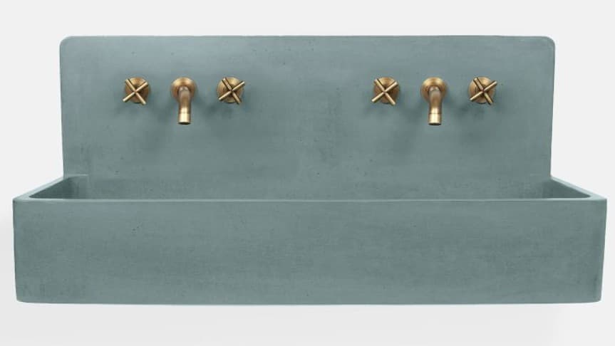A minimalist, wall-mounted dual basin sink crafted from blue-gray concrete, featuring two sets of integrated brass fixtures. Each set includes two X-handle controls for hot and cold water and a central gooseneck spout. The design emphasizes clean lines and a raw, industrial aesthetic. — 3D model