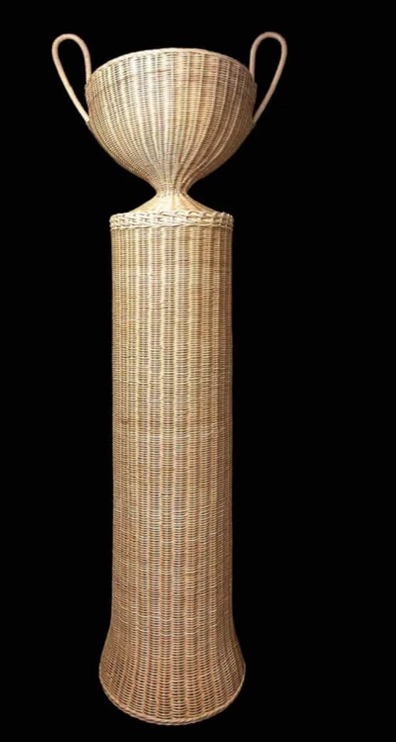 A tall, light-colored woven wicker or rattan stand, featuring a prominent urn or trophy-shaped top w… — 3D model