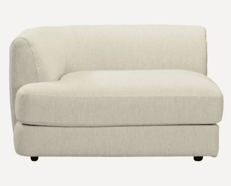 A cream-colored, modular armchair with a curved backrest and armrest. It features a textured upholstery and a low profile base with small black feet. — 3D model