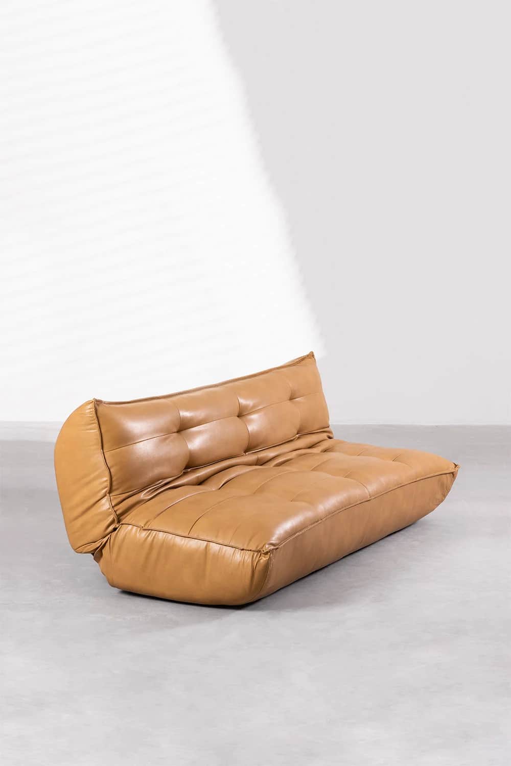 A low-profile, armless sofa with a tufted back and seat. The sofa features a rounded bolster-style a… — 3D model