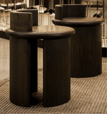A dark-stained wooden stool featuring a round seat and a low, curved backrest, supported by a monolithic cylindrical base. — 3D model