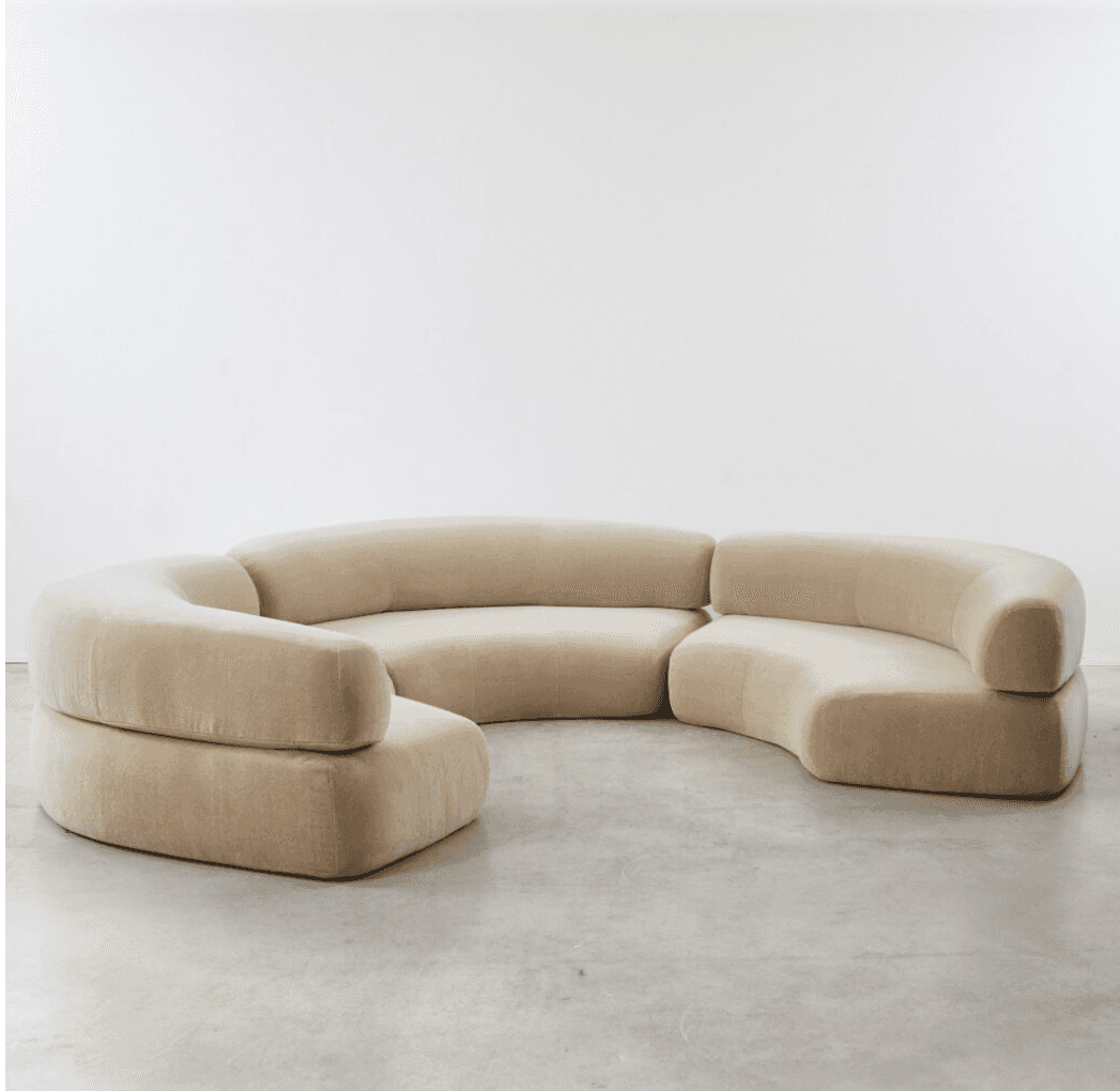 A large, modular sectional sofa with multiple curved sections, upholstered in a light beige velvet f… — 3D model
