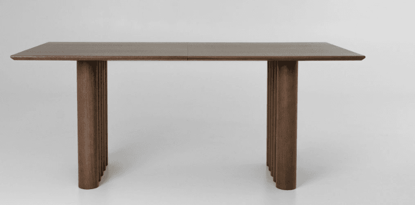 A contemporary rectangular dining table featuring a dark wood finish and distinctive fluted pedestal bases. The tabletop appears to be constructed from two panels, joined at the center, resting atop two substantial cylindrical bases composed of vertical fluted elements. The overall aesthetic is minimalist yet refined. — 3D model
