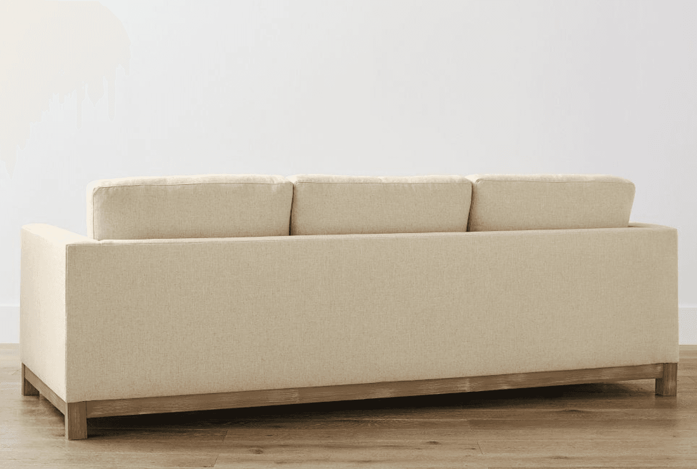 A three-seater sofa upholstered in a textured, light beige fabric. The sofa features a wooden base f… — free GLTF 3D model