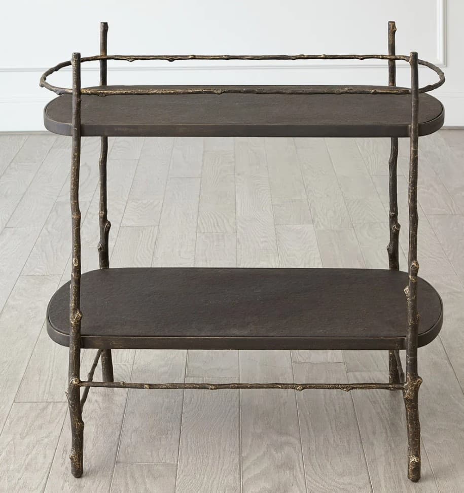 A two-tiered end table with an organic, branch-like metal frame. The frame supports two oval-shaped shelves. The top shelf has a decorative, curved railing. The legs and horizontal supports mimic natural tree branches, with a textured, weathered finish. — 3D model