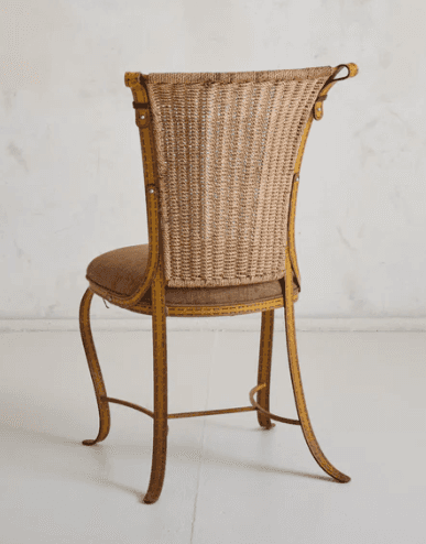 A vintage chair with a woven wicker back and a padded seat. The frame appears to be made of metal an… — free GLTF 3D model