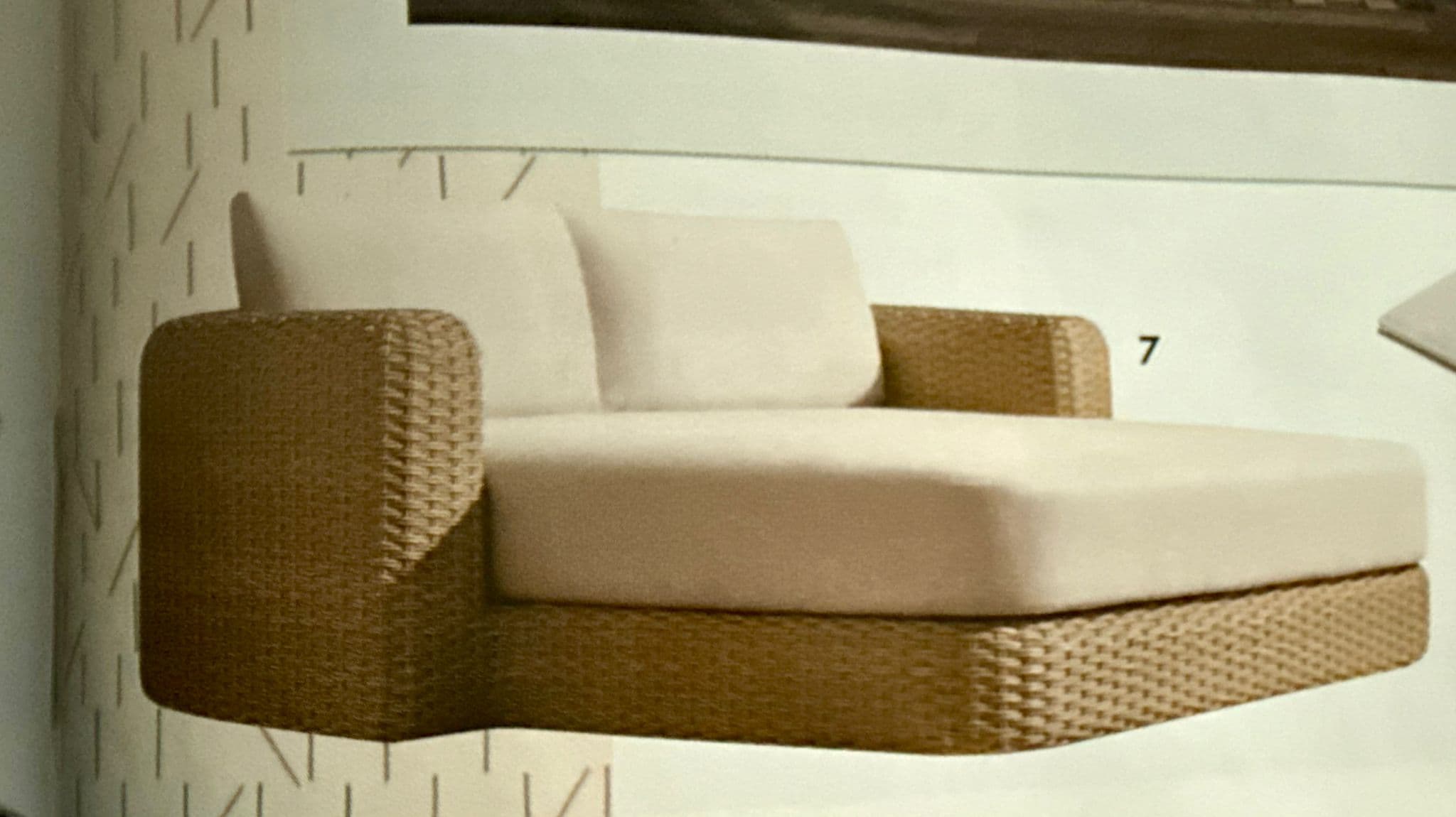 A modern outdoor chaise lounge featuring a woven wicker base and frame, with plush, light-colored fabric cushions for comfort. The chaise has a backrest with two individual cushions and a single armrest on the left side (when viewed from the front). The design is sleek and contemporary, suitable for outdoor living spaces. — 3D model