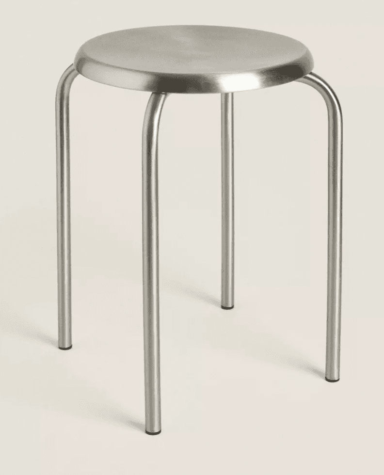 A minimalist, stackable stool featuring a round metal seat and four tubular metal legs. The entire s… — 3D model