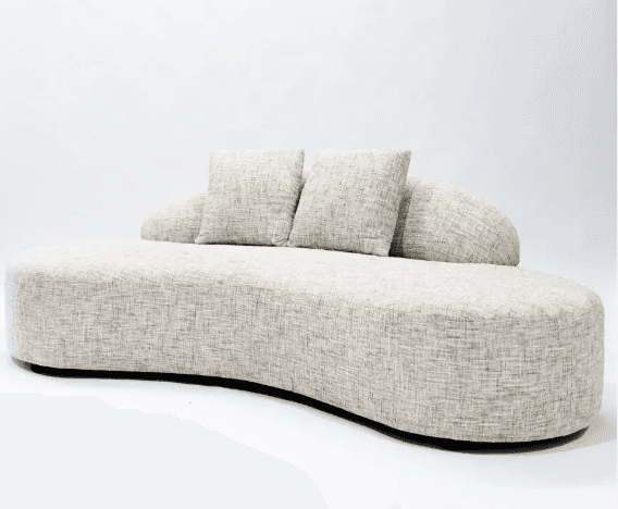 A modern, upholstered sofa with a distinctive curved silhouette. It features a low profile and a flowing, organic shape. The sofa is covered in a textured, neutral-toned fabric and includes two matching throw pillows. The base appears to be dark and slightly recessed. — 3D model