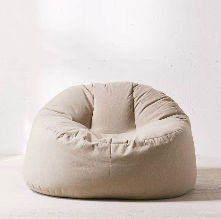 A single modern bean bag chair with a smooth, soft textile covering in a light beige or off-white co… — 3D model