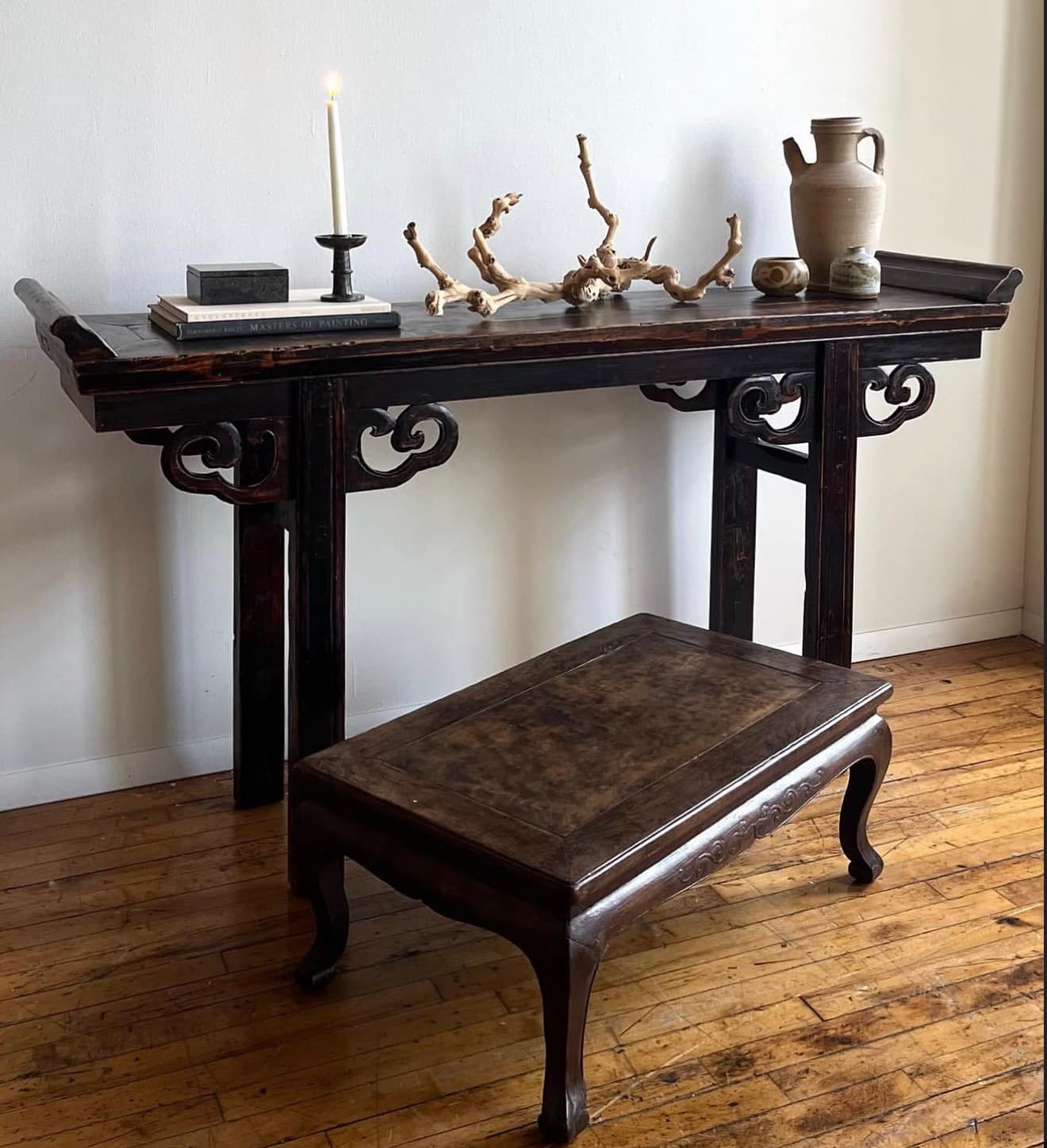 A long, narrow console table crafted from dark-stained wood, featuring a rectangular top with subtle raised edges at each end. The table is supported by four straight legs, connected to the tabletop by intricately carved, ornate scrollwork aprons on the longer sides. The overall aesthetic is traditional Asian, with a rustic yet refined finish. — 3D model