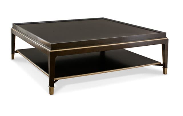 A square coffee table featuring a dark finish, a lower storage shelf, and brass details. The top surface has a raised edge, and the legs are tapered with brass sabots. — 3D model