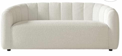 A contemporary, subtly curved sofa upholstered in a cream bouclé fabric, featuring vertical channel tufting along its backrest and integrated arms. Its design is armless with a continuous, low-profile back and arm structure, presenting a sleek and modern aesthetic. — 3D model