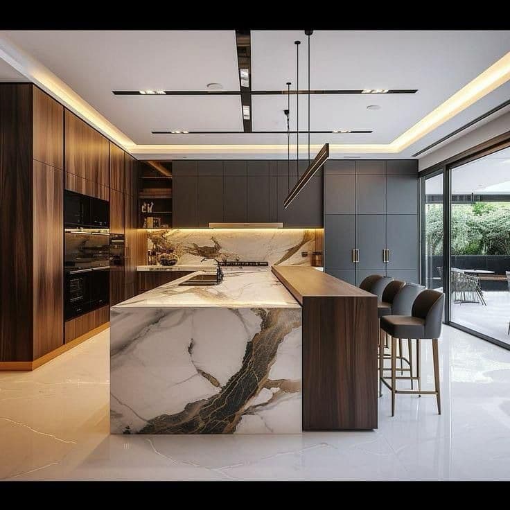 A contemporary kitchen island featuring a marble body with prominent veining, an integrated dark-colored sink, and an attached wooden bar counter. Three modern bar stools with gray upholstered seats and slender golden-toned metal frames are positioned beneath the wooden counter. The island exhibits clean lines and a minimalist aesthetic. — 3D model