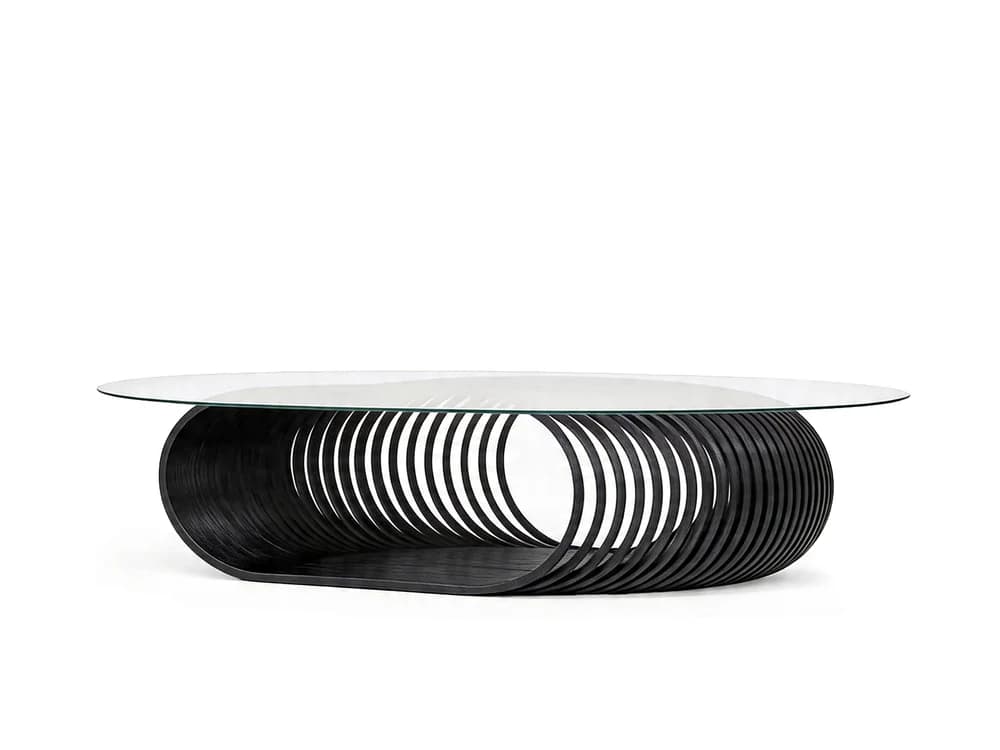 An oval-shaped coffee table featuring a clear glass top supported by a distinctive sculptural base made of numerous dark, parallel wooden slats arranged in an elliptical, coiled pattern. The base rests on a matching dark wooden plinth. — 3D model