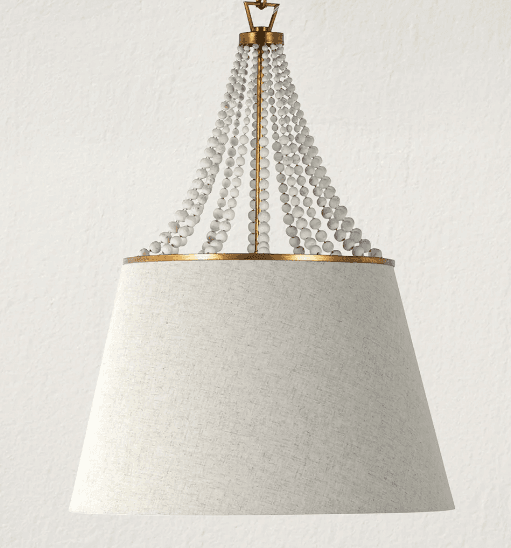 A chandelier featuring a conical lampshade made of textured light-colored fabric. The upper part of the chandelier is adorned with multiple strands of small, round, white beads, suspended from a golden metal frame. The lampshade has a golden trim at the top rim. — 3D model