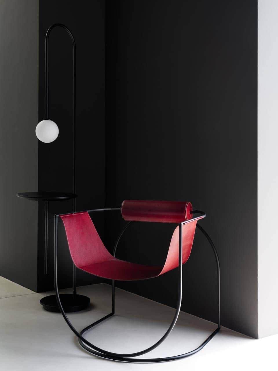 A contemporary rocking lounge chair featuring a continuous black tubular metal frame and a deep, bur… — 3D model