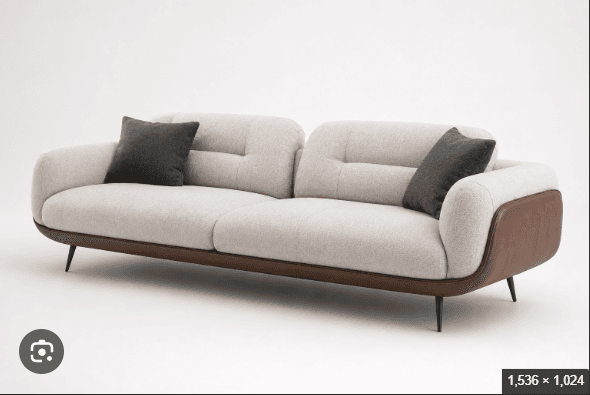 A contemporary two-seater sofa featuring light-colored, textured fabric upholstery on the cushions and inner frame, contrasted with dark brown leather or faux leather accents on the lower frame and outer armrests. The sofa has a sleek, slightly curved profile, button-tufted back cushions, and rests on slender, angled black metal legs. Two dark gray throw pillows are positioned on the sofa. — 3D model