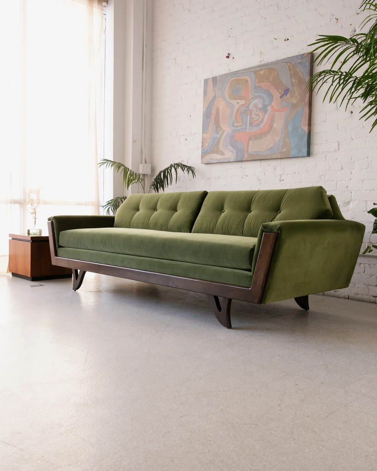 An olive green Mid-Century Modern sofa featuring a button-tufted backrest and an exposed dark wood f… — free GLTF 3D model