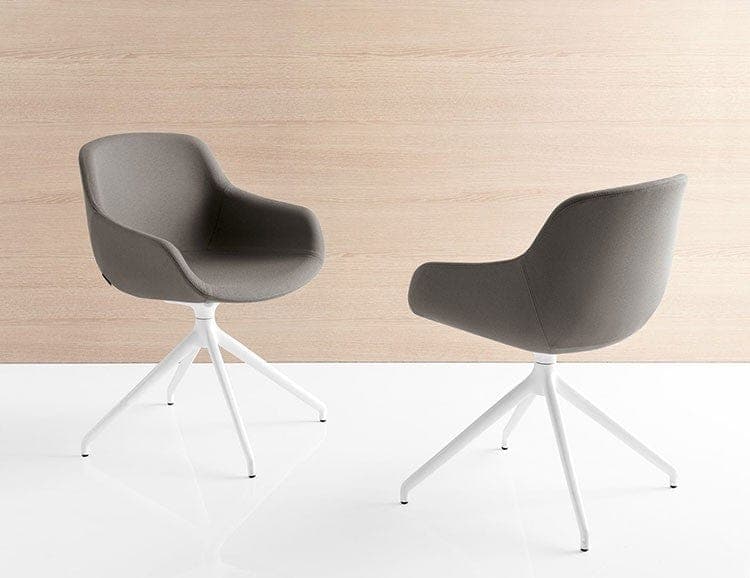 A pair of upholstered armchairs with a molded seat and backrest, featuring integrated armrests. The chairs are supported by a four-legged white metal base with a swivel mechanism. The upholstery appears to be a textured fabric in a medium grey hue. The chairs are positioned on a white reflective surface against a light wood-paneled background. — 3D model