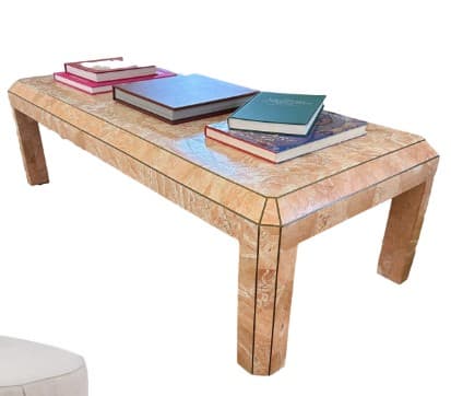 A rectangular coffee table constructed from what appears to be solid travertine or a travertine-veneered material. The design features a thick, slab-like top supported by four substantial block legs. The construction exhibits clean, angular lines with mitered joints visible at the corners of the top and where the legs meet the tabletop. The material has a distinctive light brown/beige hue with natural textural variations characteristic of travertine, lending it a monolithic and minimalist aesthetic. — 3D model