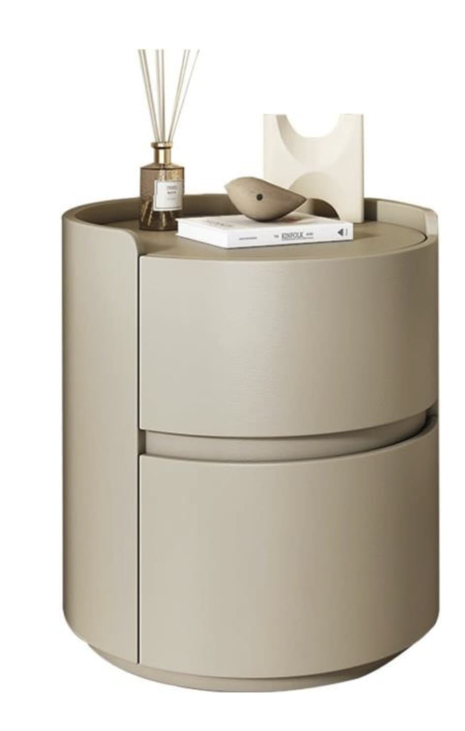 A cylindrical nightstand with two drawers, featuring a smooth, matte finish. The top surface has a slight overhang and a curved edge. Decorative objects, including a reed diffuser, a book, and two abstract sculptures, are placed on top. — 3D model