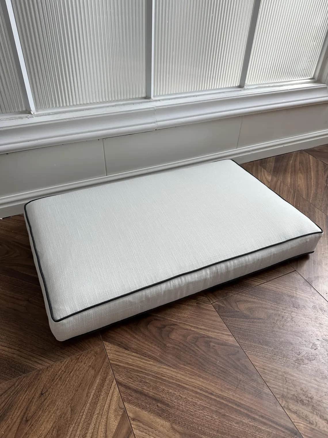 A light gray rectangular cushion with rounded corners and contrasting black piping along its edges,… — free GLB 3D model