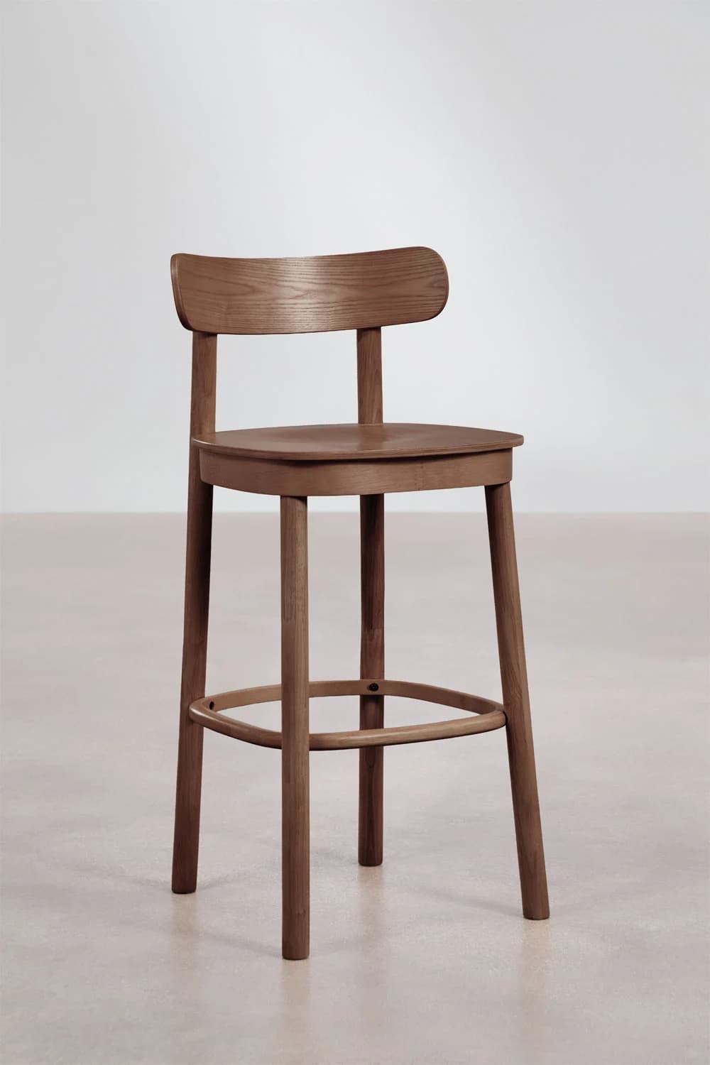 A modern wooden bar stool featuring a curved backrest, a round seat, and a simple, integrated footrest connecting its four tapered legs. — 3D model