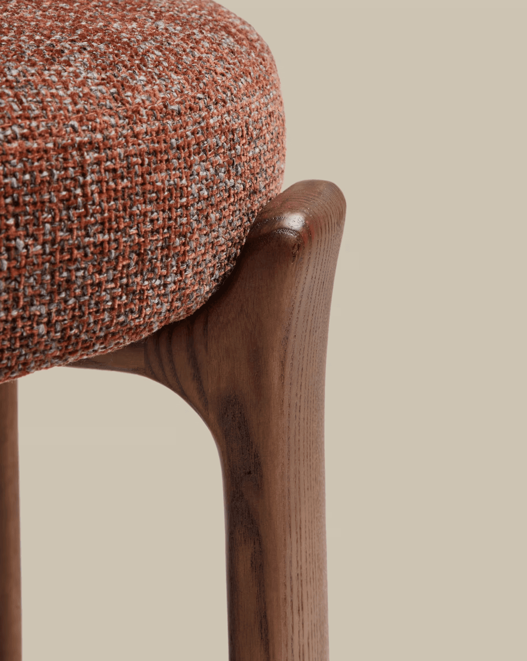 A close-up image of a modern stool, showcasing its rounded, textured upholstered seat in a reddish-b… — 3D model