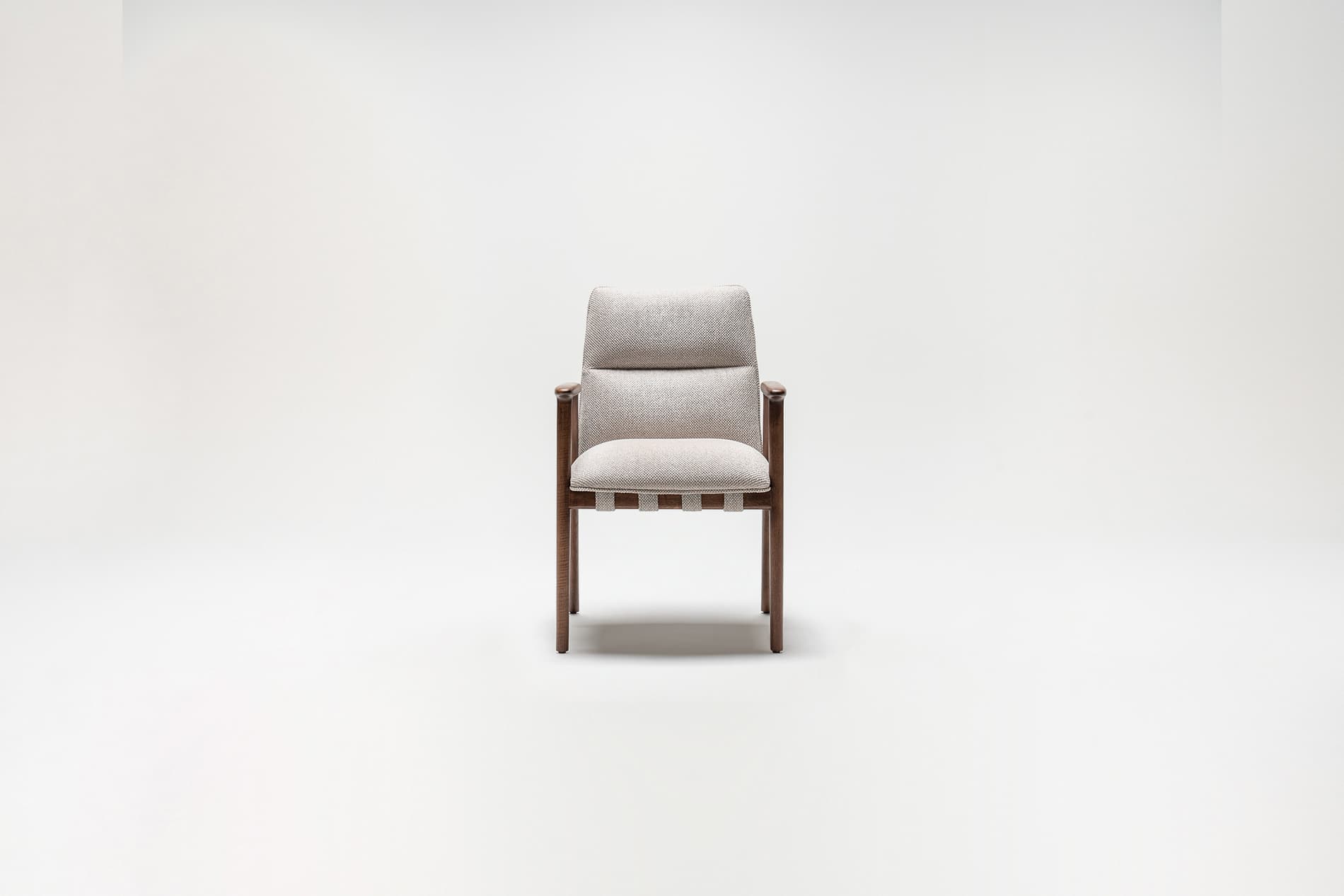 A modern armchair with a wooden frame and upholstered seat and backrest. The seat is supported by woven straps. The backrest is segmented into two distinct cushions, with the upper cushion appearing slightly larger. The armrests are integrated into the wooden frame. — 3D model