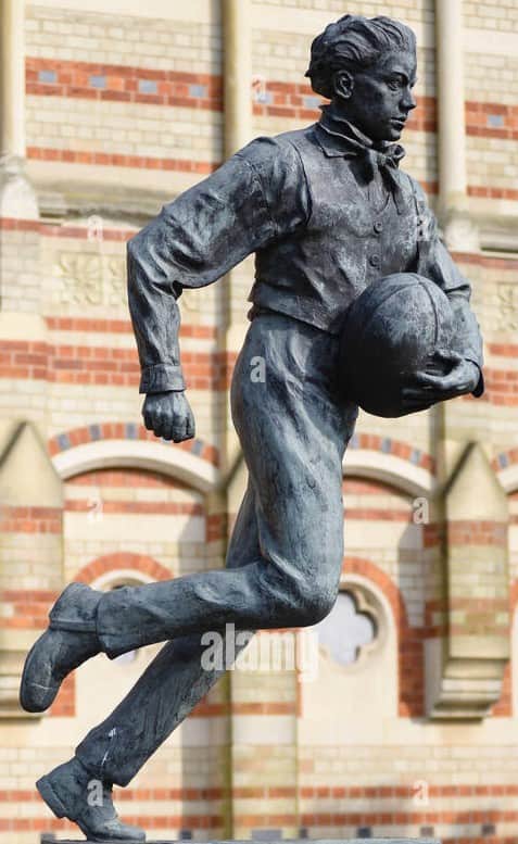 A bronze sculpture depicting a male figure in motion, appearing to be running with a rugby ball clut… — 3D model