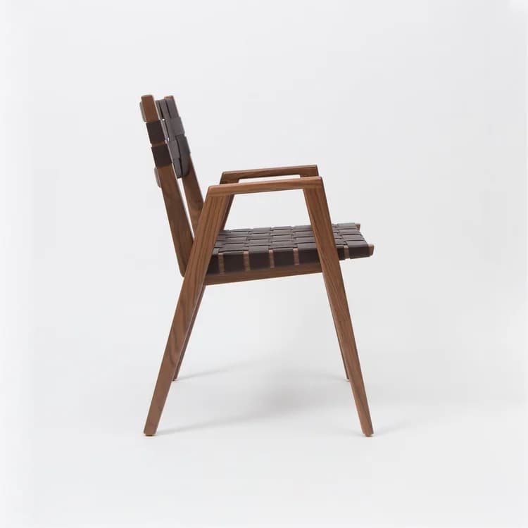 A modern armchair with a wooden frame and woven leather seat and backrest. The frame has clean lines and tapered legs. The seat and backrest are constructed from dark brown leather straps interlaced to form a supportive surface. — 3D model