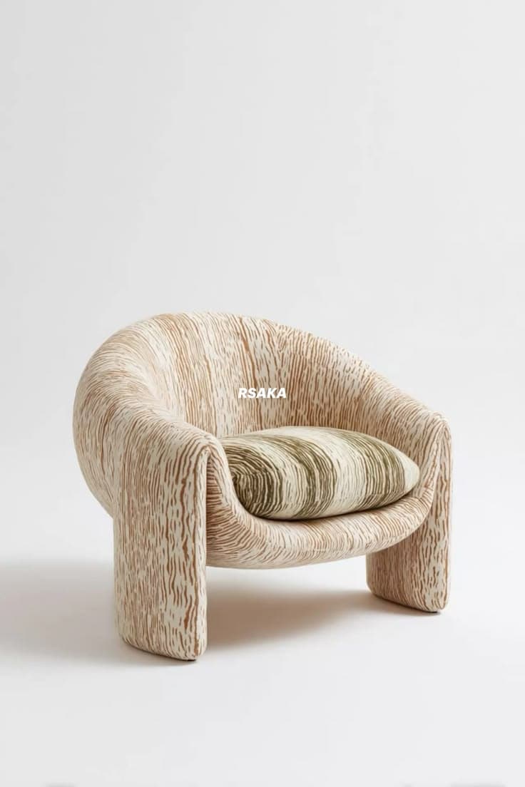 A low-profile armchair with an organic, rounded form, upholstered in a textured fabric resembling wood grain. It features a continuous, curvilinear shape with no distinct legs, and includes a striped accent pillow. — 3D model