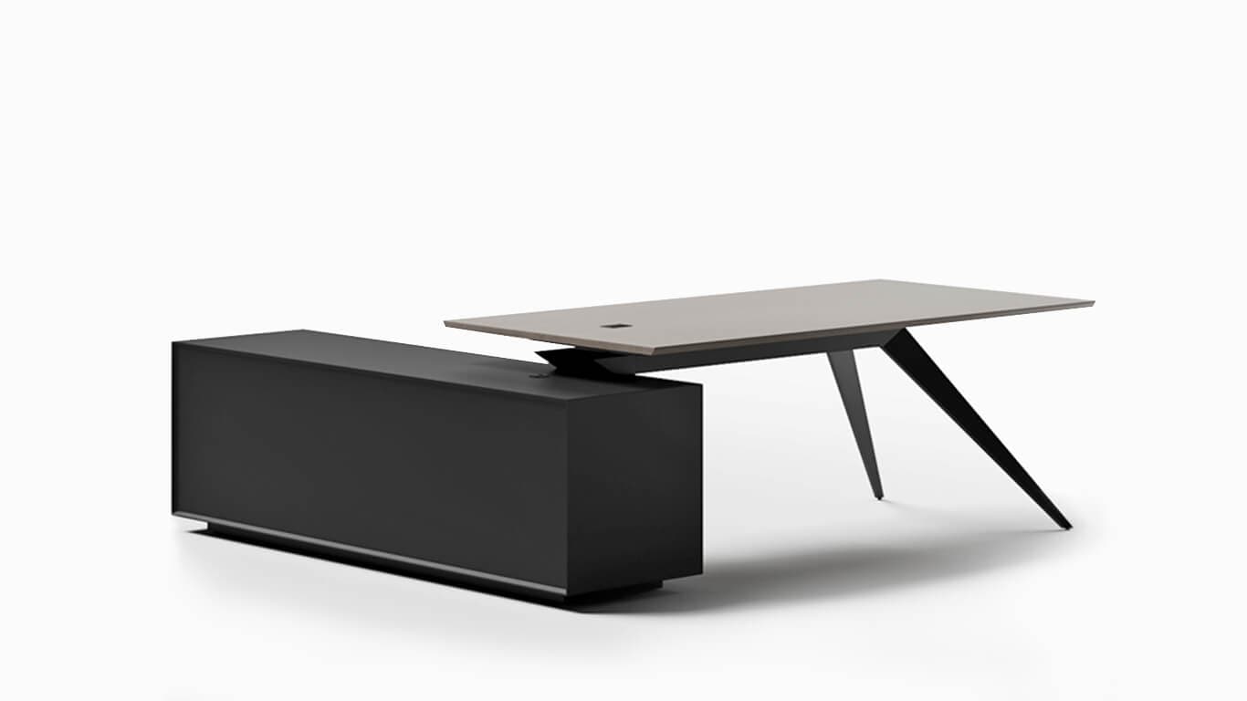 A modern executive desk featuring a rectangular, light-colored desktop that appears to float above a dark, rectangular credenza and is supported by two sharply angled, dark-colored metal legs. The credenza provides a substantial base and integrated storage, while the desk surface includes a small, dark grommet for cable management. The design emphasizes clean lines, contrasting materials, and a contemporary aesthetic. — 3D model