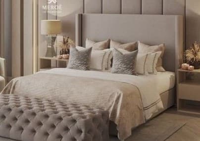 An upholstered bed featuring a tall, winged headboard with vertical channel tufting, paired with a matching upholstered frame. The bed is adorned with several decorative pillows and a duvet. Positioned at the foot of the bed is a rectangular, deeply tufted upholstered bench, presenting a cohesive and luxurious bedroom ensemble. — 3D model