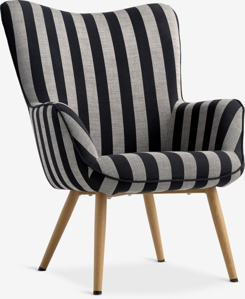 A contemporary upholstered lounge chair featuring a distinctive black and light gray striped fabric. The chair has a gently curved, high backrest and integrated armrests, all finished with piping along the seams. It is supported by four splayed, tapered wooden legs with dark protective caps. The overall design suggests comfort and a modern aesthetic. — 3D model