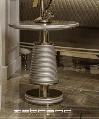 A modern accent table featuring a round white marble top, a central tapered pedestal with horizontal… — 3D model