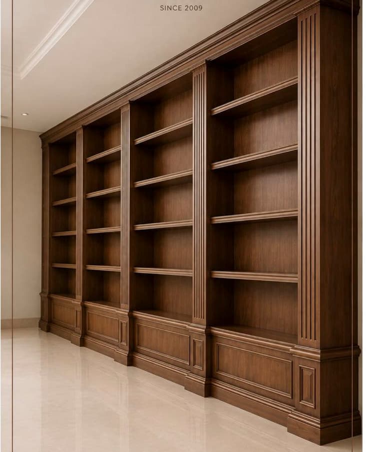 A large, multi-section wooden bookcase with a traditional design, featuring three distinct bays separated by decorative fluted pilasters. The unit is constructed from dark-stained wood, exhibiting a rich grain. It includes extensive crown molding at the top and a substantial, stepped base with decorative paneling along the lower sections of each bay. Each bay contains multiple fixed shelves, providing ample storage for books and decorative items. — 3D model